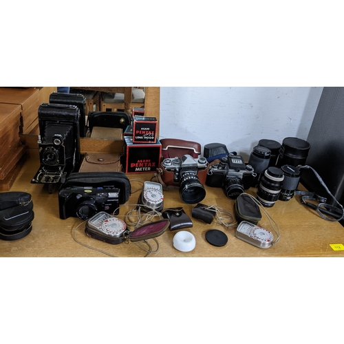 124 - A collection of vintage film camera and digital cameras, accessories and equipment to include a Pent... 