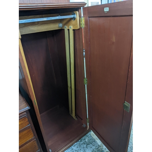 258 - An imitation mahogany wardrobe of small proportions with cantilever hanging rail on plinth base, inn... 