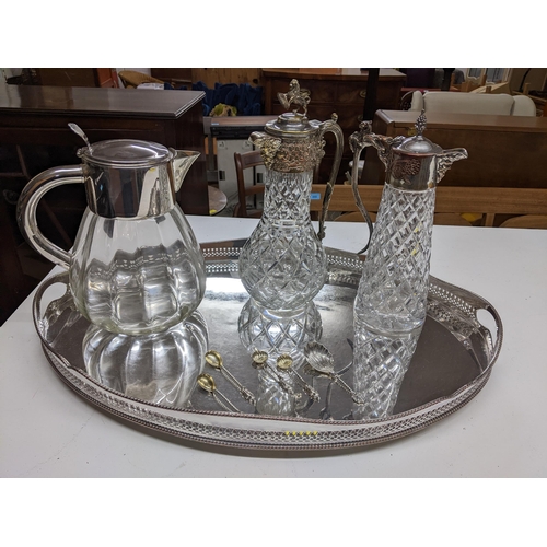 79 - A silver plate on copper-oval gallery tray, two silver plated and cut glass claret jugs, one with Ba... 