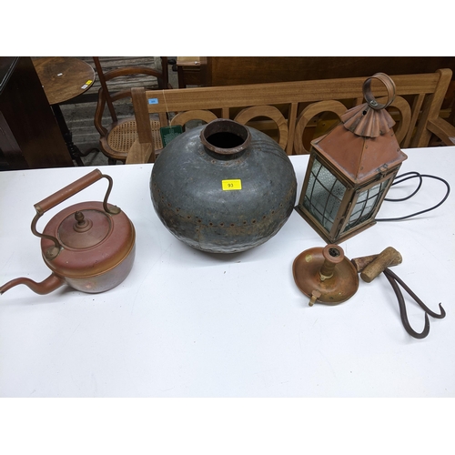 93 - A selection of metal ware to include an African water carrier metal bowl, copper porch light with gl... 