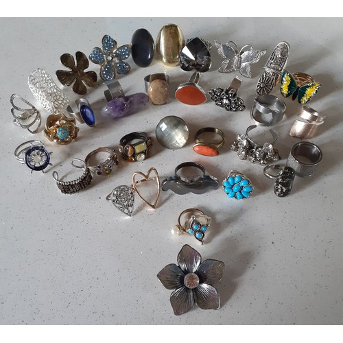 154 - A quantity of modern gold tone and silver tone costume rings to include a Retro stainless steel and ... 