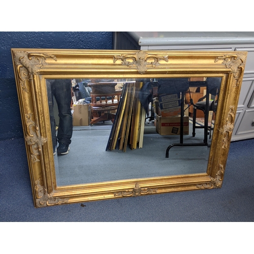 415 - A vintage gilt wall hanging mirror having a moulded frame with bevelled glass 116.5cm x 86.5cm Locat... 