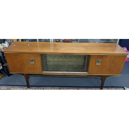 480 - A mid 20th century teak sideboard having two sliding glass doors, flanked by two cupboard doors, 74.... 