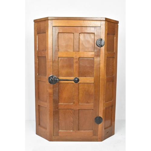 57 - Robert 'Mouseman' Thompson (1876-1955) An oak hanging corner cupboard, circa 1955, with panelled doo... 