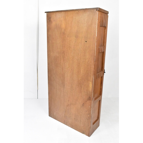 57 - Robert 'Mouseman' Thompson (1876-1955) An oak hanging corner cupboard, circa 1955, with panelled doo... 