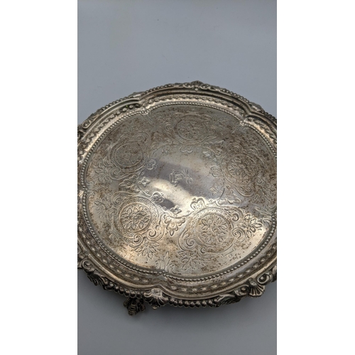 92 - A three-footed silver card tray having engraved floral detail, hallmarked London 1874, 246.3g Locati... 