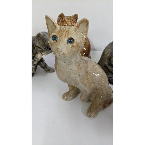 306 - A group of seven Winstanley ceramic cats to include a Winstanley ginger cat with glass eyes, 21cm h ... 