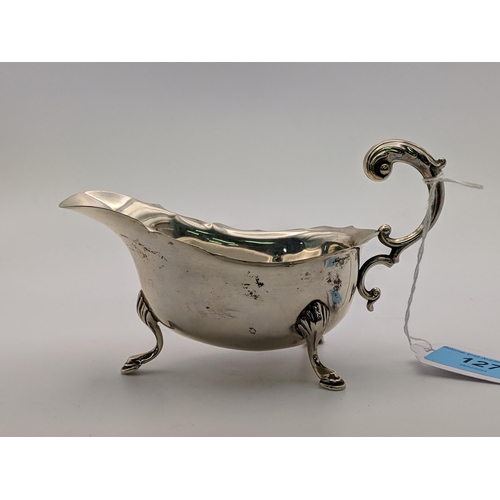 127 - A silver sauce /gravy boat with a 'c' scroll handle, raised on cabriole legs and pad feet, Birmingha... 