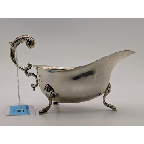 127 - A silver sauce /gravy boat with a 'c' scroll handle, raised on cabriole legs and pad feet, Birmingha... 