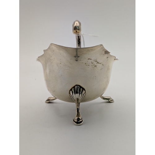 127 - A silver sauce /gravy boat with a 'c' scroll handle, raised on cabriole legs and pad feet, Birmingha... 