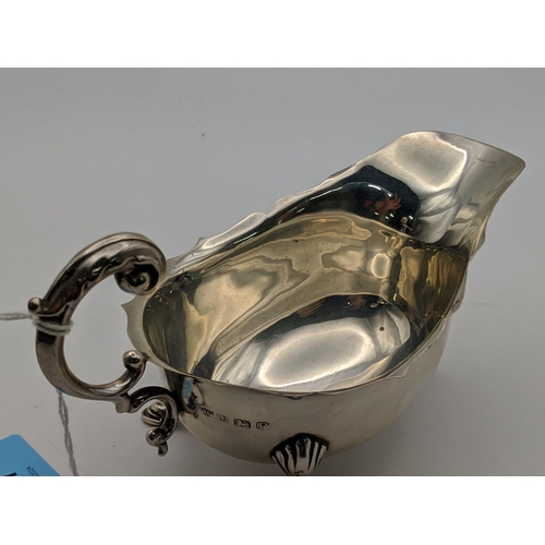 127 - A silver sauce /gravy boat with a 'c' scroll handle, raised on cabriole legs and pad feet, Birmingha... 