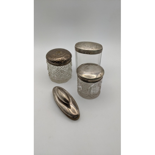 130 - Three dressing table jars, one having floral engraved detail to its lid, Birmingham 1897, along with... 