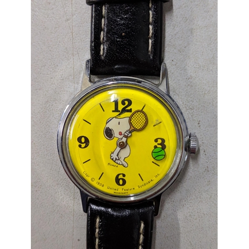 73 - A Snoopy tennis unisex wristwatch with a quartz movement, yellow face, Arabic and baton dials on a b... 