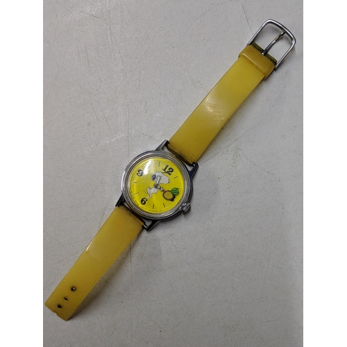 74 - A Snoopy tennis unisex wristwatch with a quartz movement, yellow face, Arabic and baton dials on a b... 