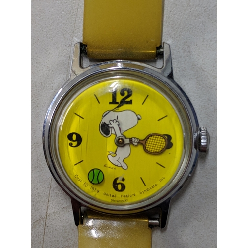 74 - A Snoopy tennis unisex wristwatch with a quartz movement, yellow face, Arabic and baton dials on a b... 