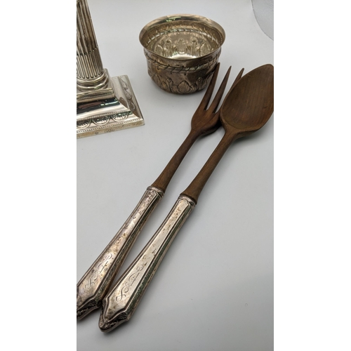 111 - Sterling silver handled and wooden salad servers, together with a silver embossed bowl and candlesti... 