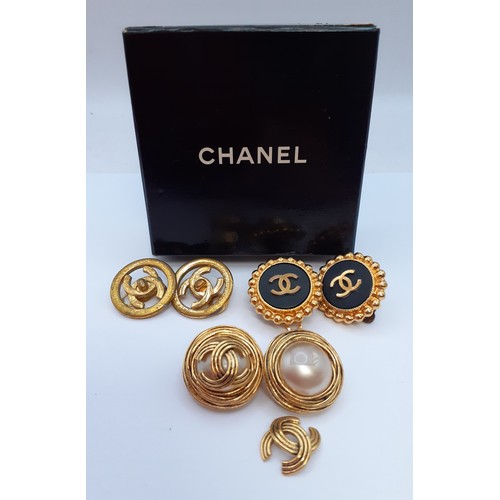 Chanel- Three pairs of Chanel gold tone clip-on earrings to include a pair of Autumn 1993 black wood with central convex disk having an intertwined gold tone CC logo, a pair of Spring 1997 gold tone intertwined CC logo earrings and a pair of Autumn 1994 gold tone and central faux pearl earrings A/F with gold tone intertwined CC logo together with a branded Chanel box. Location:Cab