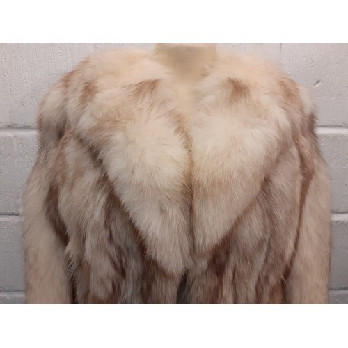 63 - A late 20th Century arctic fox coat with brown tinge having a shawl collar having a blue lining, no ... 