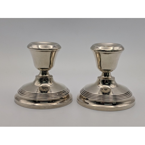 81 - A pair of silver candlesticks and silver paperweight surmounted by a dog, combined weight 514.9g Loc... 