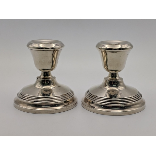 81 - A pair of silver candlesticks and silver paperweight surmounted by a dog, combined weight 514.9g Loc... 