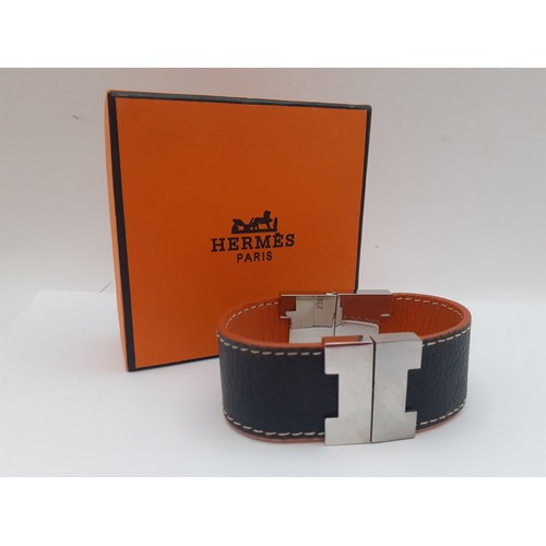 12 - Hermes-A reversible brown and orange leather 'Leurie' wrist strap having silver tone hardware, inter... 