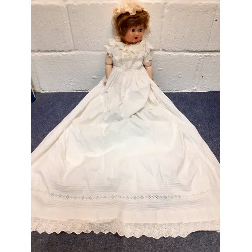 248 - A 20th Century Continental doll with painted face and open mouth, jointed arms and legs wearing an e... 