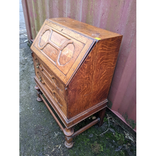 170 - An early 20th century oak bureau having a fall flap above two drawers, on bulbous supports, Location... 