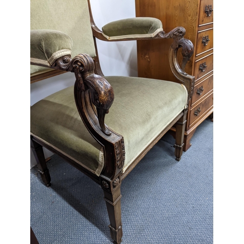 84 - An Edwardian walnut carved and upholstered open armchair, the arms with carved, scrolled leaf and bi... 