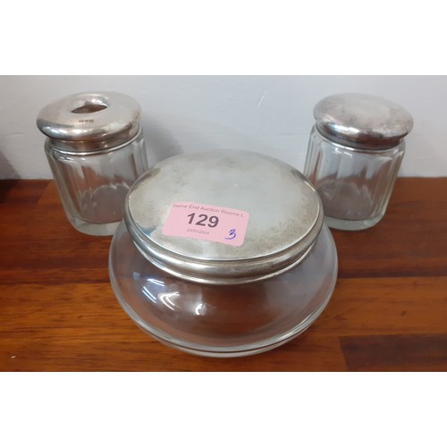 129 - Three early 20th Century silver topped and clear glass dressing table jars, weight of silver lids 11... 
