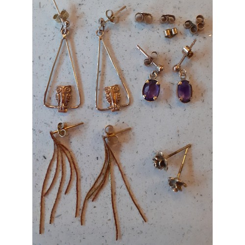 134 - A quantity of 9ct gold and yellow metal earrings having 9ct and 15ct gold earring backs, stamped, to... 