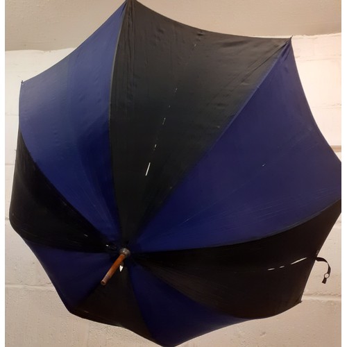 144 - A mid 20th Century cane handled umbrella in black and navy with painted porcelain handle and yellow ... 