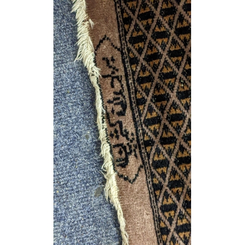 320 - A Pakistani hand woven rung having a green ground with elephant foot motifs and bearing signature, 2... 