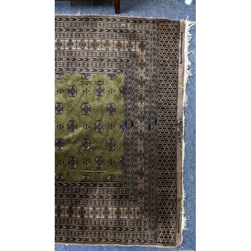 320 - A Pakistani hand woven rung having a green ground with elephant foot motifs and bearing signature, 2... 