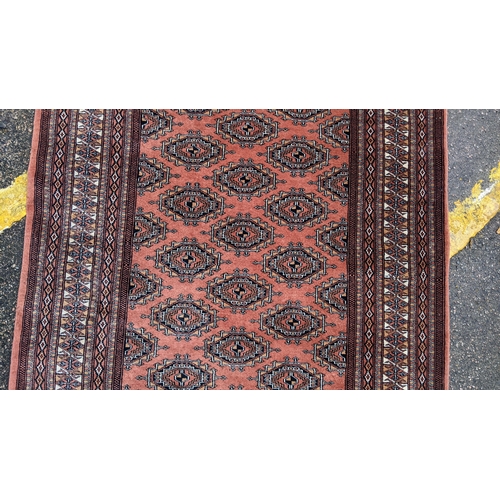 325 - A Bokhara hand woven red ground rug having geometric designs and tasselled ends, 190cm x 126cm
Locat... 