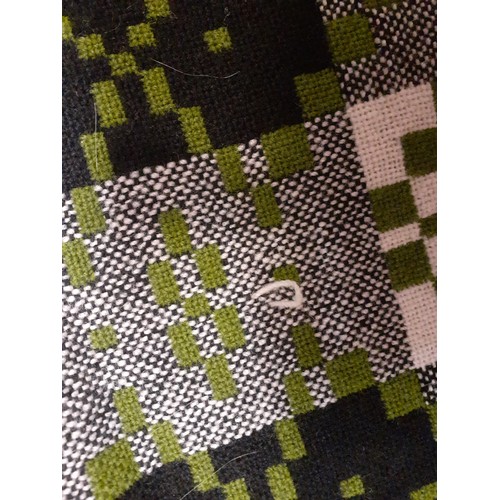 69 - A vintage green, black and cream Welsh wool blanket in a patchwork check design having a fringe to 2... 
