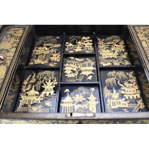 125 - An early 19th century chinoiserie black lacquered and gilt highlighted work box, the box of rounded ... 