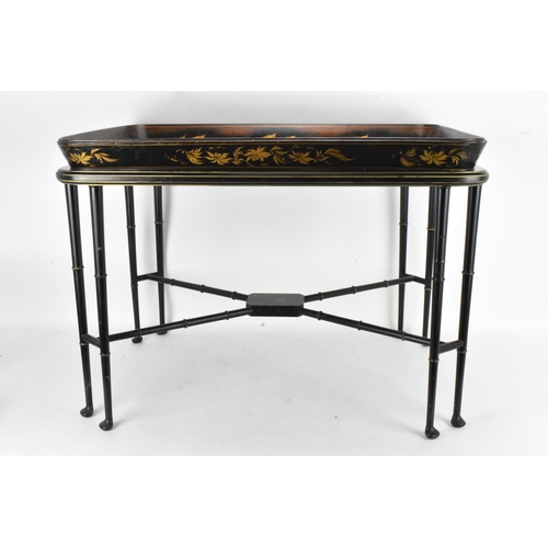 126 - A tray top table having a Victorian black lacquered papier mache tray with a floral border enclosing... 