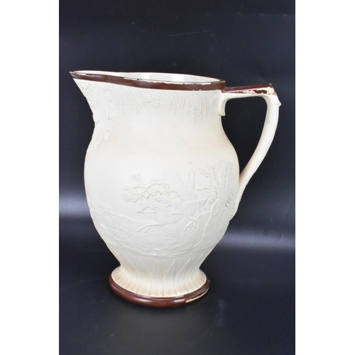 133 - A circa 1800 Turner stoneware jug, moulded decoration depicting a hunting scene and with brown paint... 