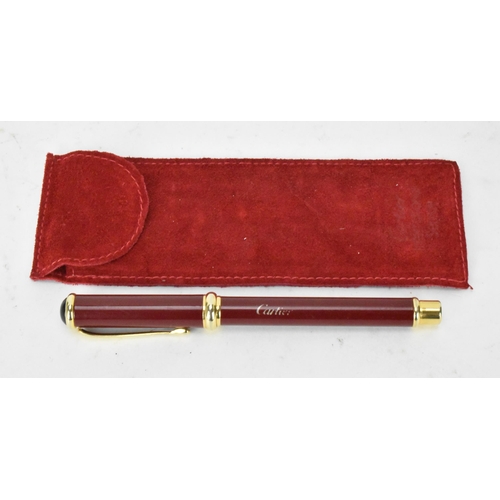 138 - A Must De Cartier fountain pen with a red lacquer case and lid, with gold plated detail and having a... 