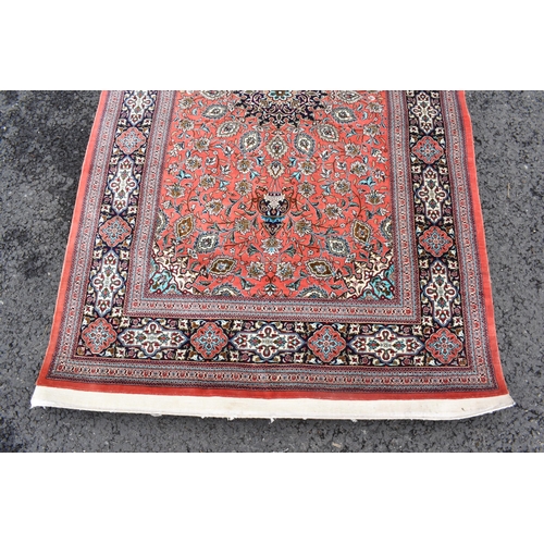 139 - A Isfahan part silk rug with entwined flowering vine decoration on a salmon pink ground with a signa... 