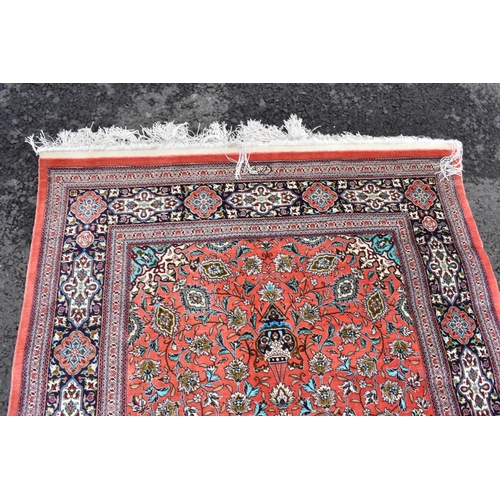 139 - A Isfahan part silk rug with entwined flowering vine decoration on a salmon pink ground with a signa... 