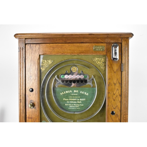 142 - An Allwin De Luxe oak cased penny slot machine, circa 1920, with internal metal ball track, central ... 