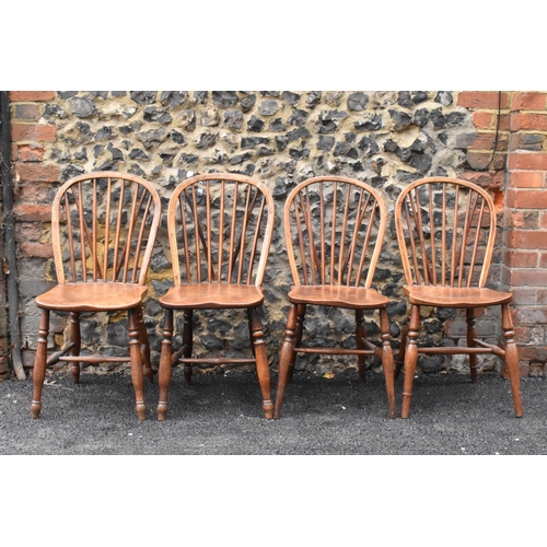 144 - A set of four 19th century elm and ash Windsor dining chairs, having spindle hoop shaped backs, turn... 