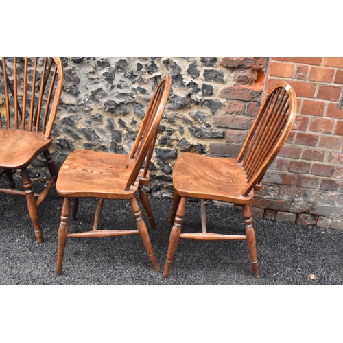 144 - A set of four 19th century elm and ash Windsor dining chairs, having spindle hoop shaped backs, turn... 