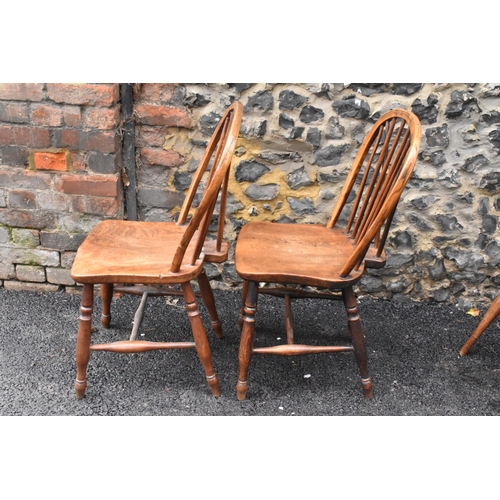 144 - A set of four 19th century elm and ash Windsor dining chairs, having spindle hoop shaped backs, turn... 