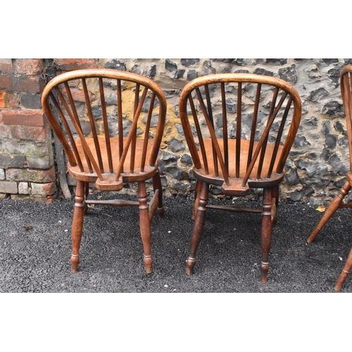 144 - A set of four 19th century elm and ash Windsor dining chairs, having spindle hoop shaped backs, turn... 