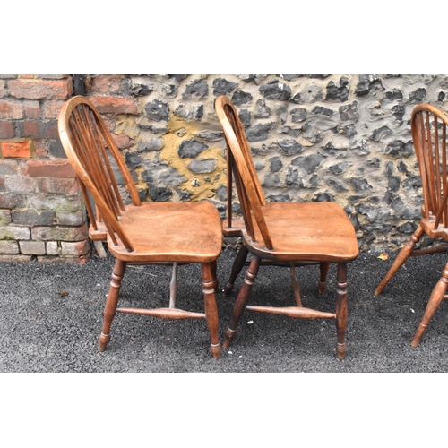 144 - A set of four 19th century elm and ash Windsor dining chairs, having spindle hoop shaped backs, turn... 