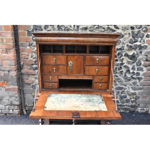 151 - An early 18th century walnut quarter cut secretaire chest on a later stand, having a cavetto moulded... 