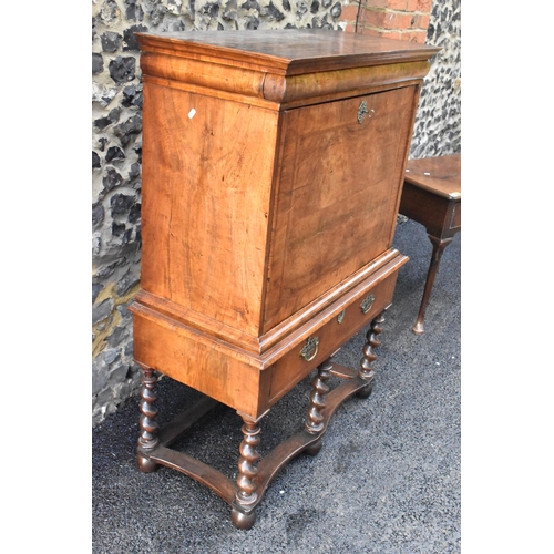 151 - An early 18th century walnut quarter cut secretaire chest on a later stand, having a cavetto moulded... 