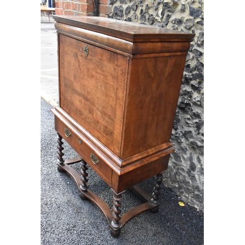 151 - An early 18th century walnut quarter cut secretaire chest on a later stand, having a cavetto moulded... 